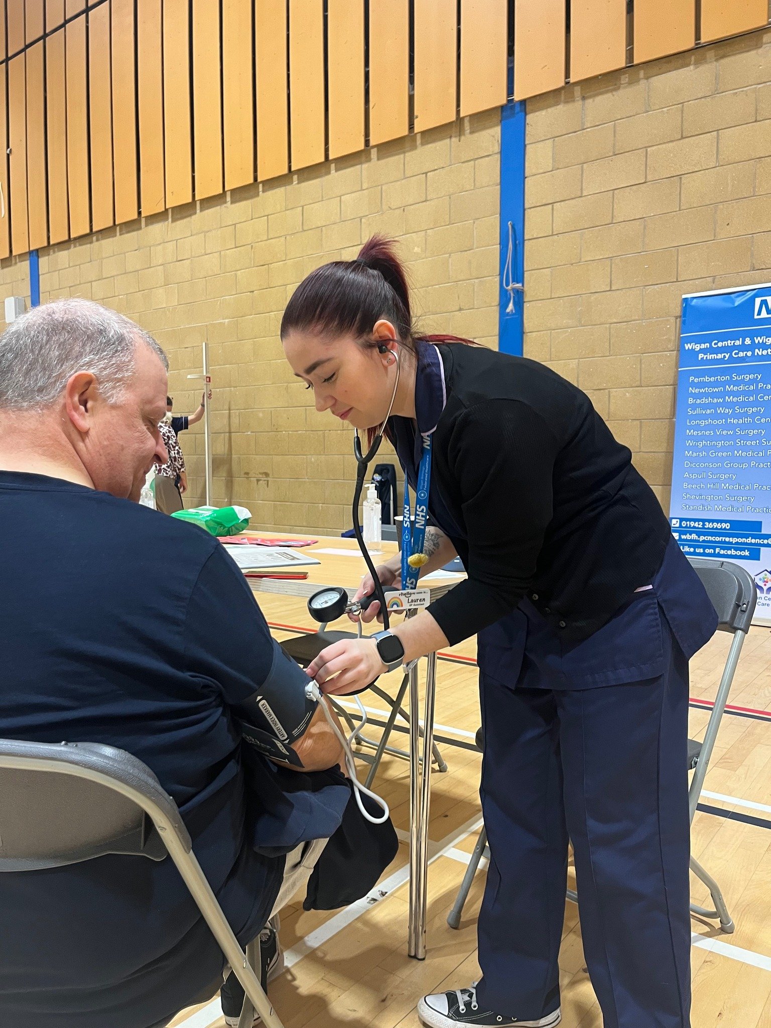 A nurse testing a man's blood pressure at a leisure centre
