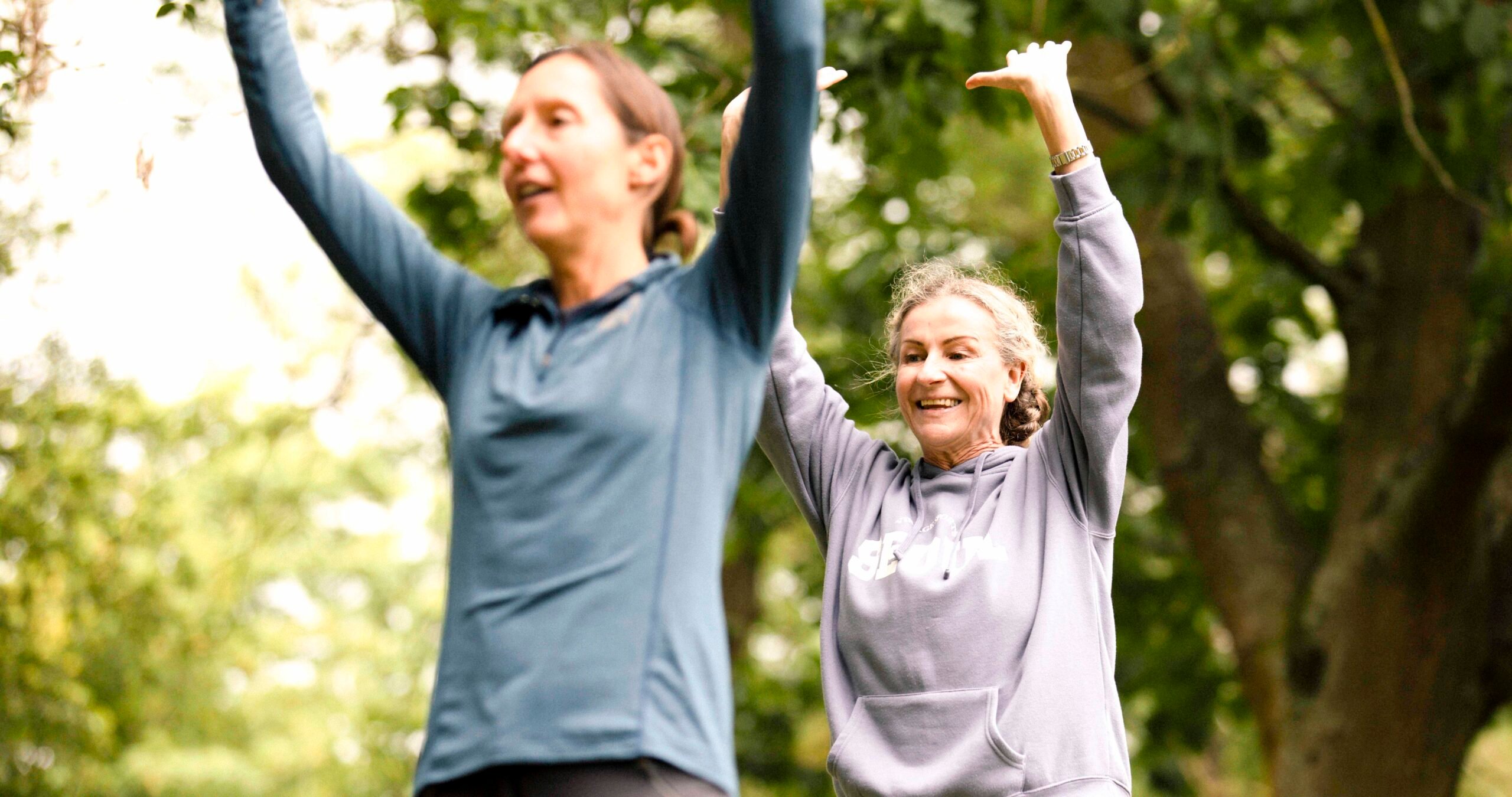 Two women at a park exercise class