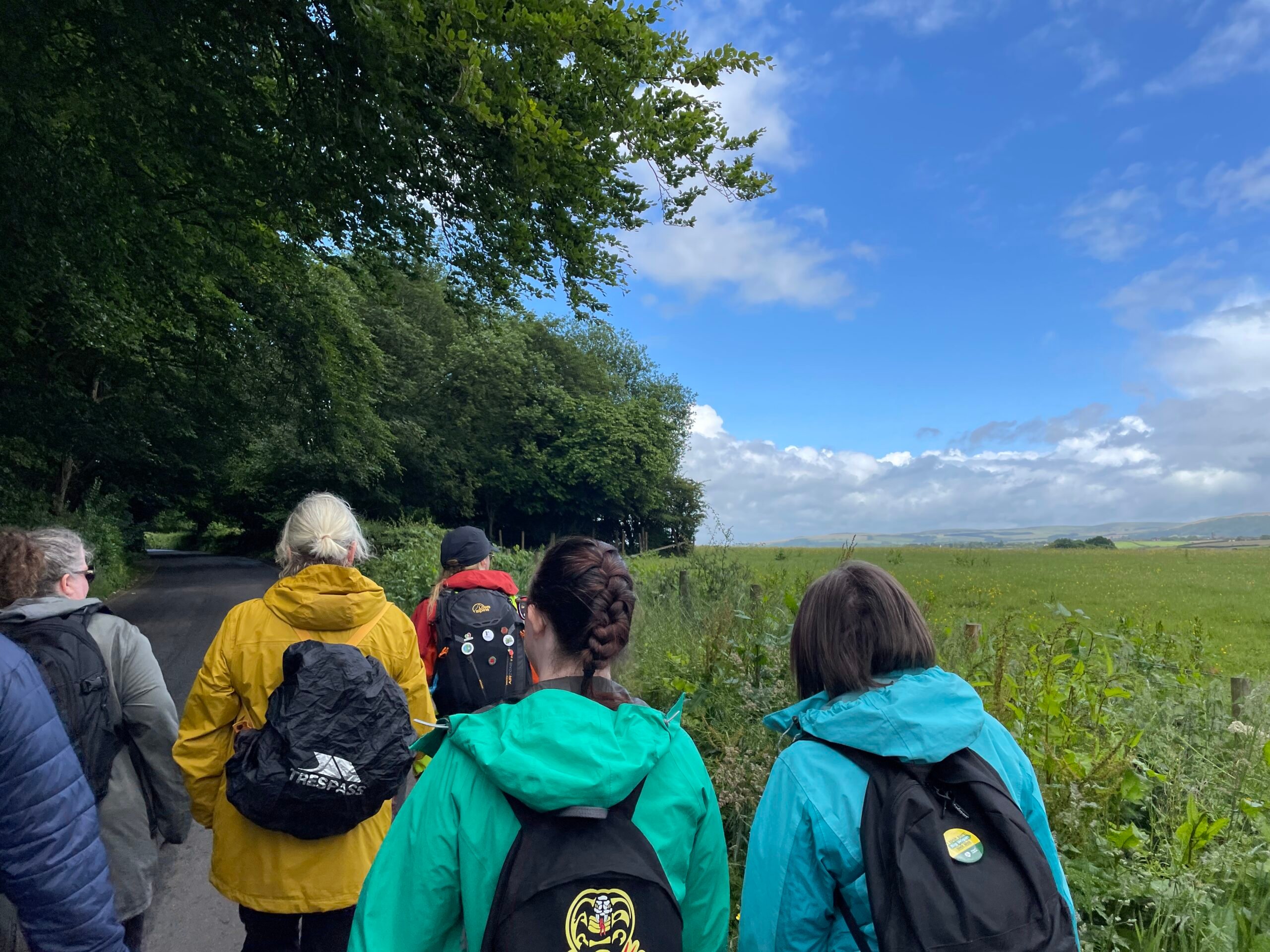 A group of walkers pass a field in Haigh
