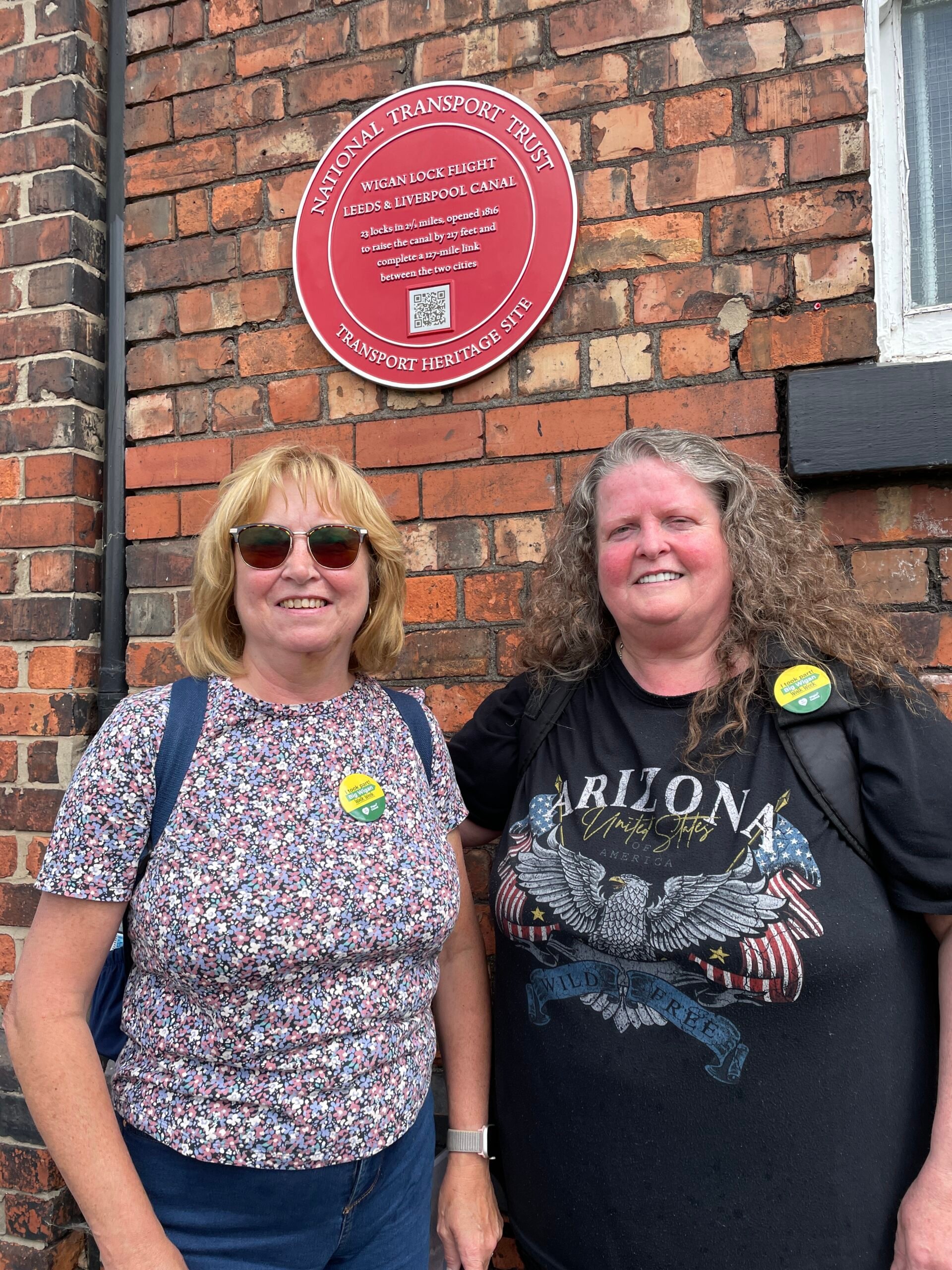 Walkers with a National Transport Trust plaque on the Leeds-Liverpool Canal