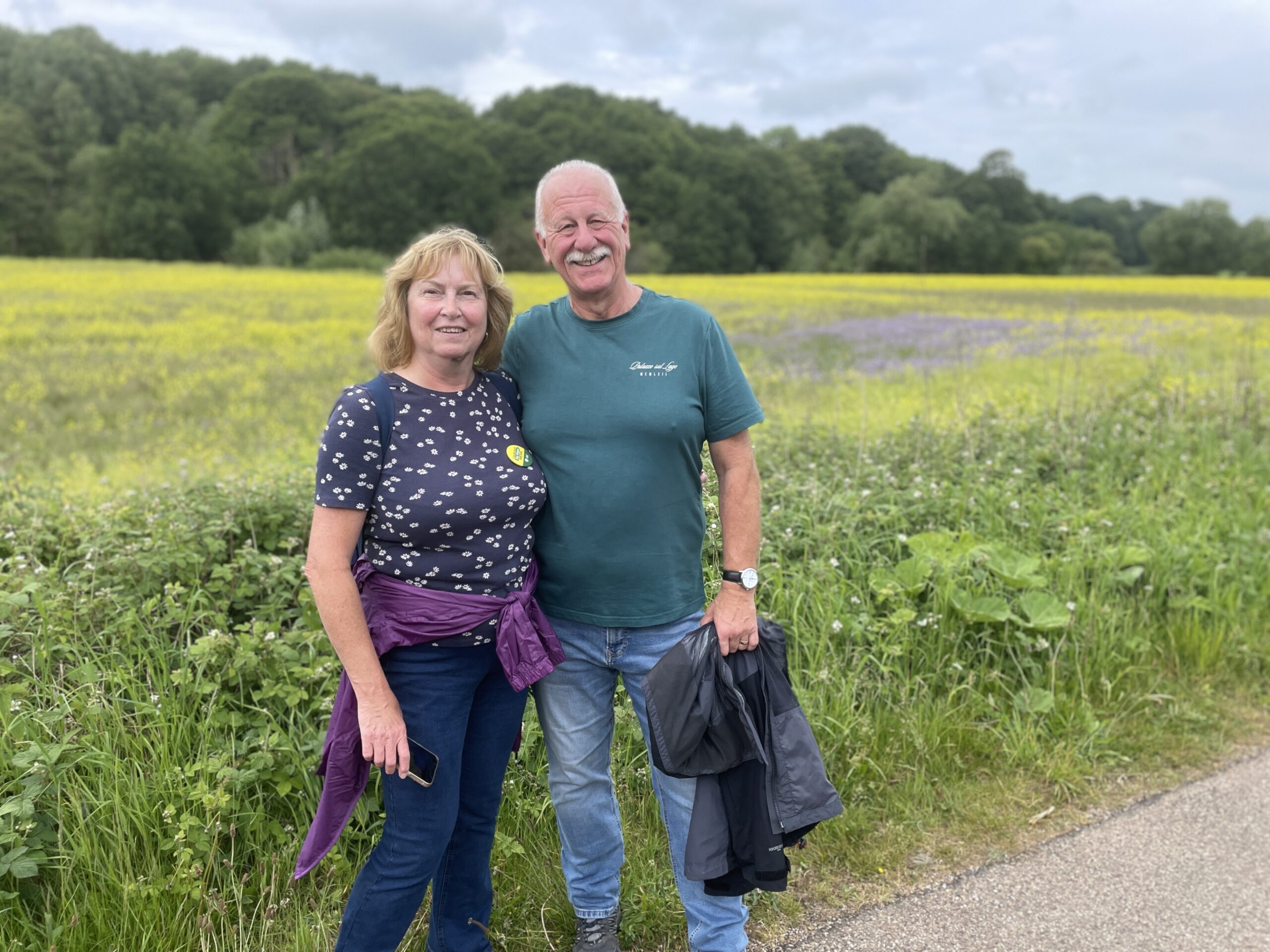 A couple standing in front of a flowering field