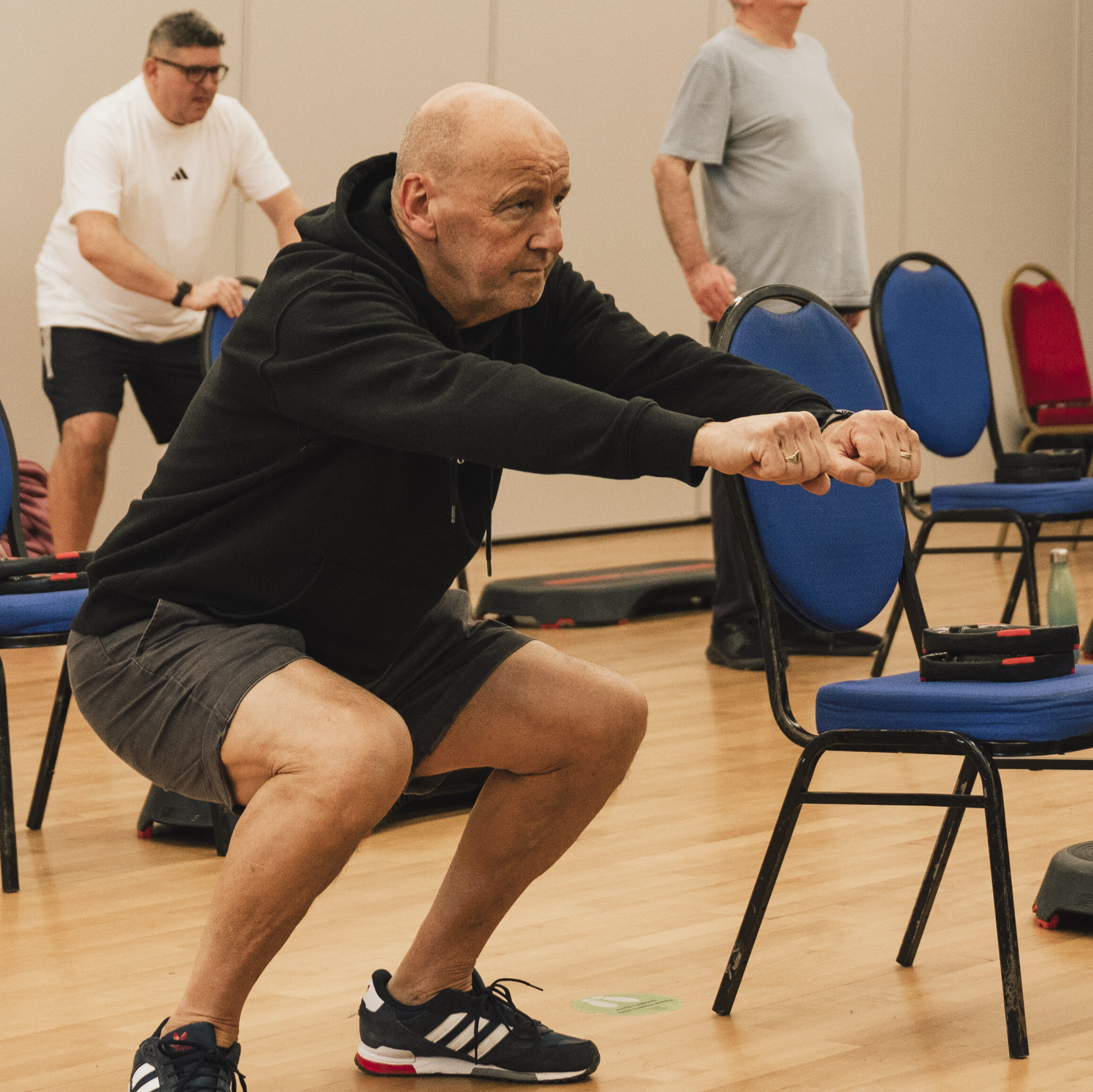 Man doing a squat at a strength class