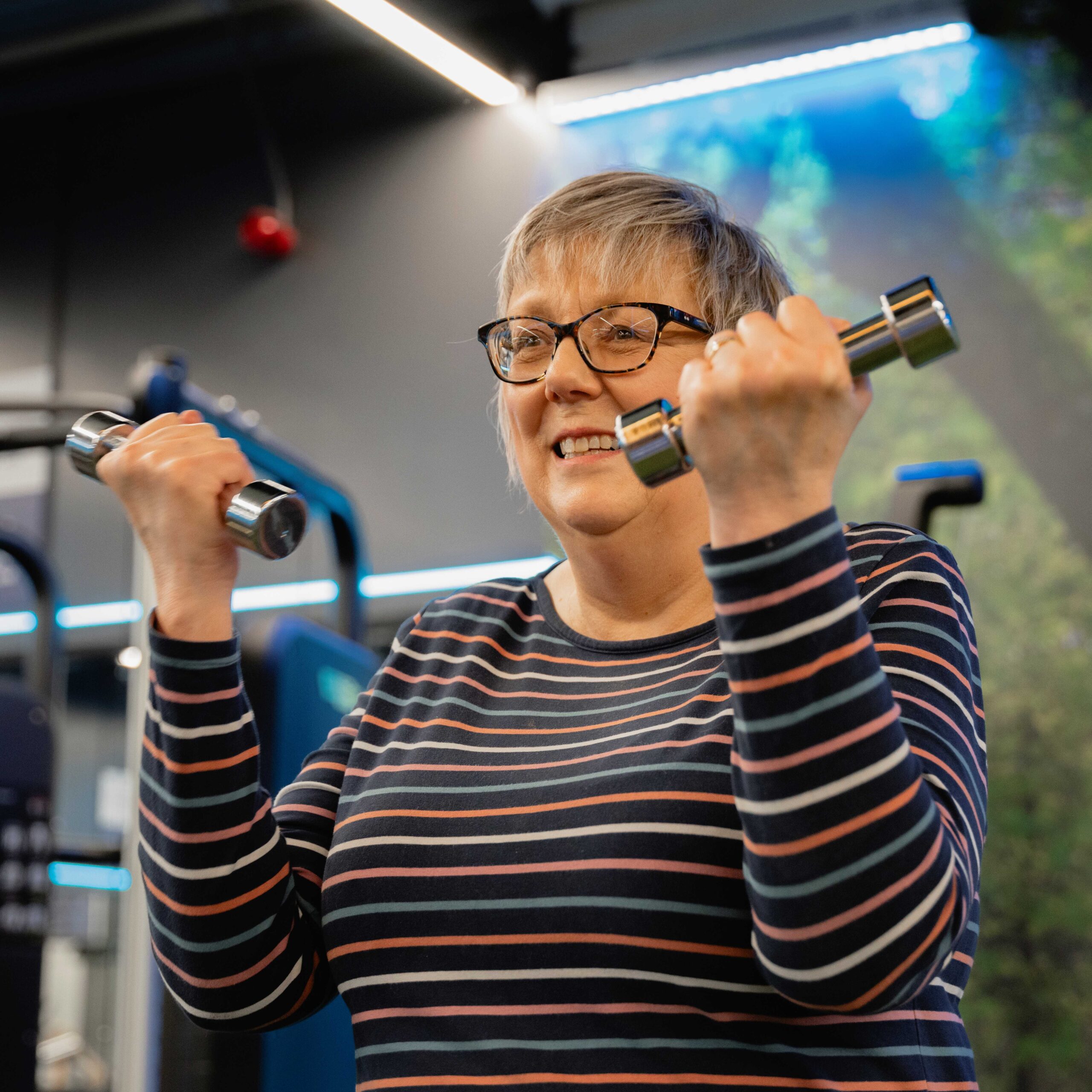 Older woman with dumbbells lifting light weights