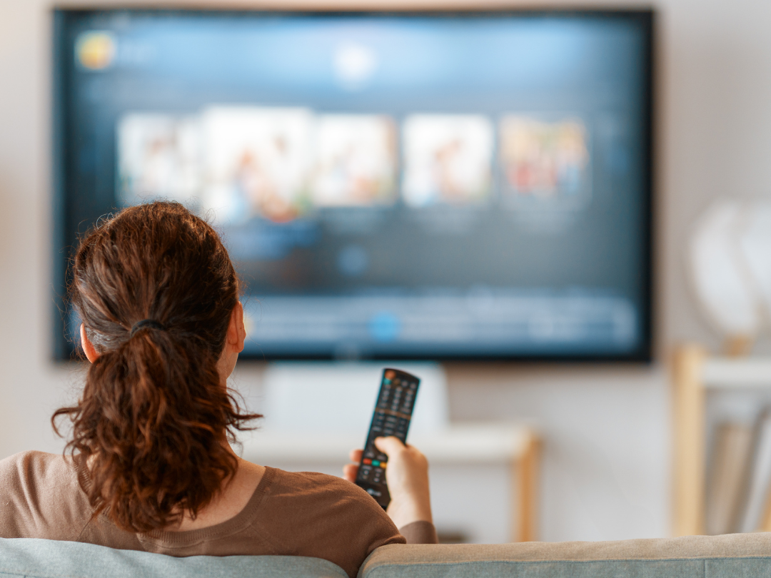 Woman holding tv remote watching tv