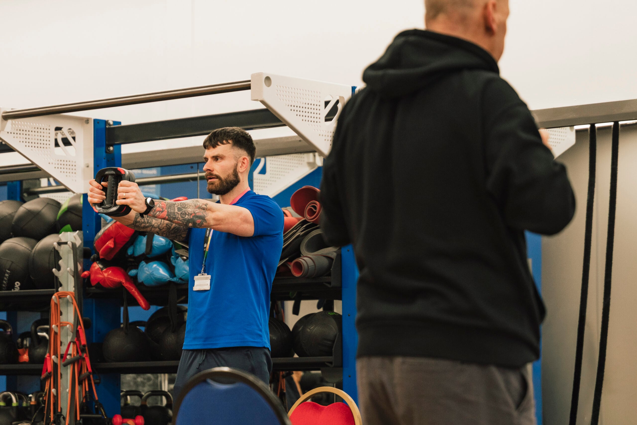 A male instructor leads a Be Well exercise class